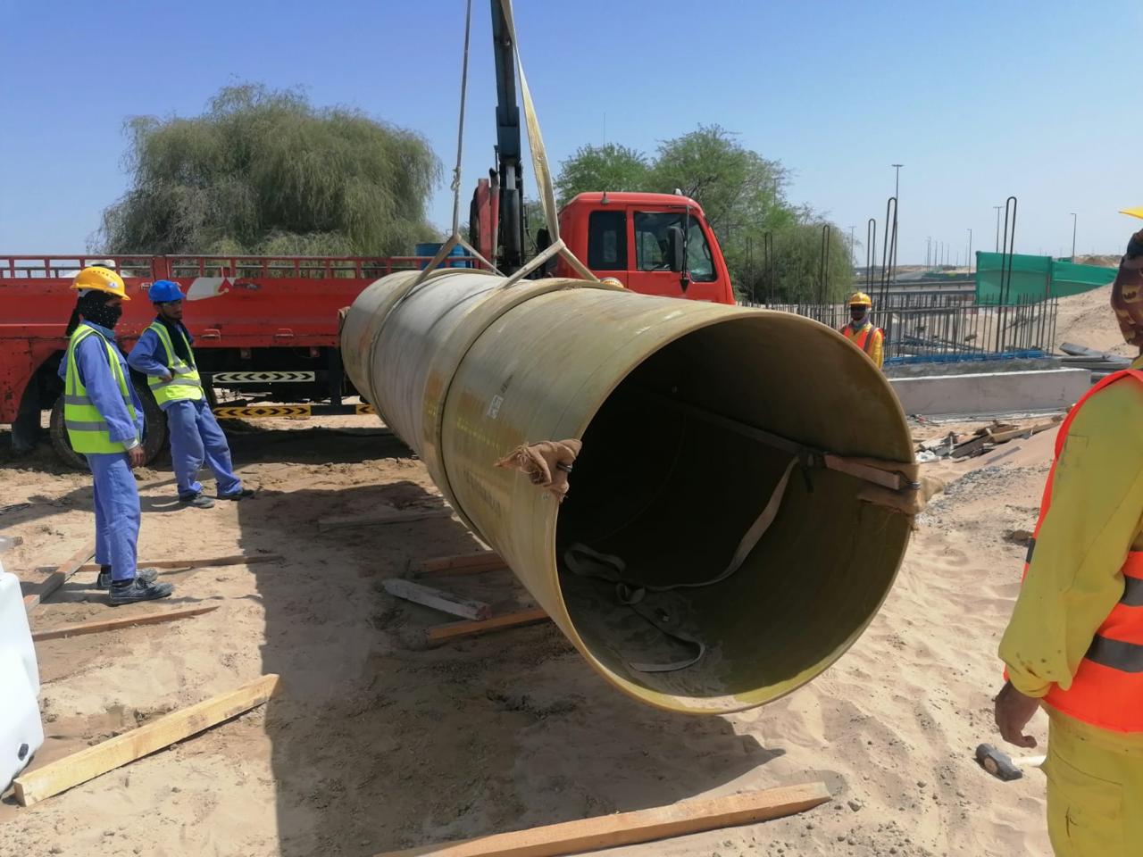 Steel pipeline segments and fittings staged on site in a utility installation area