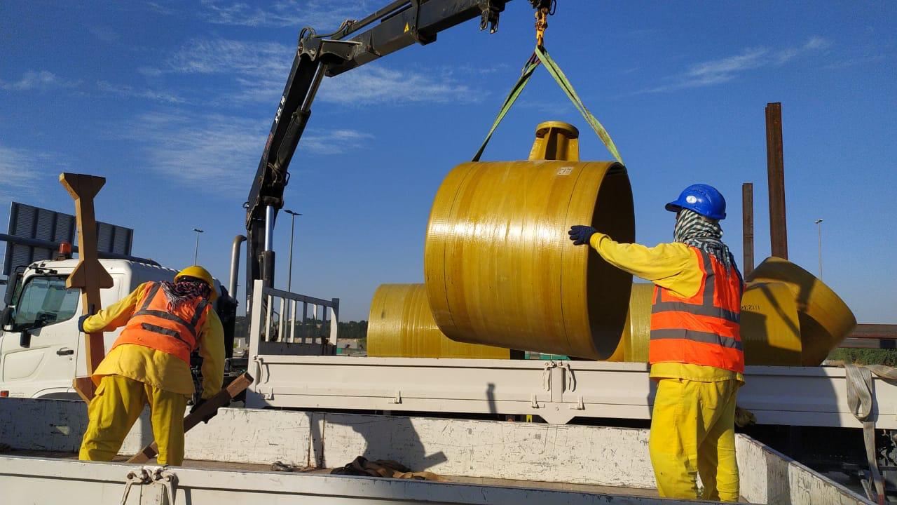 Pipeline spool pieces and connectors organized near a fabrication area on site