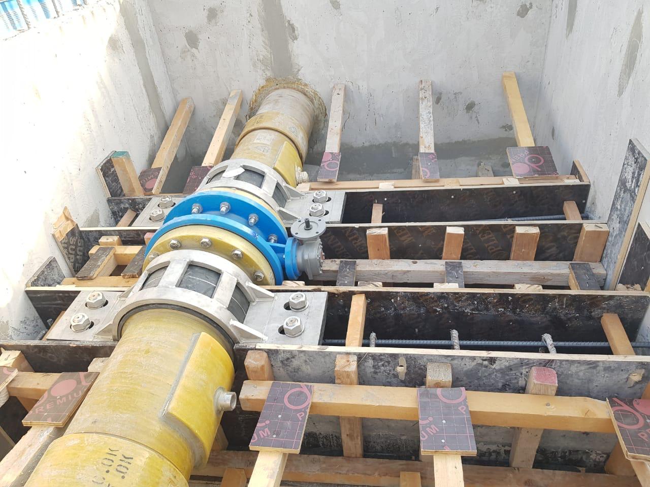 Pipeline construction site with heavy equipment and steel piping layout in a work zone