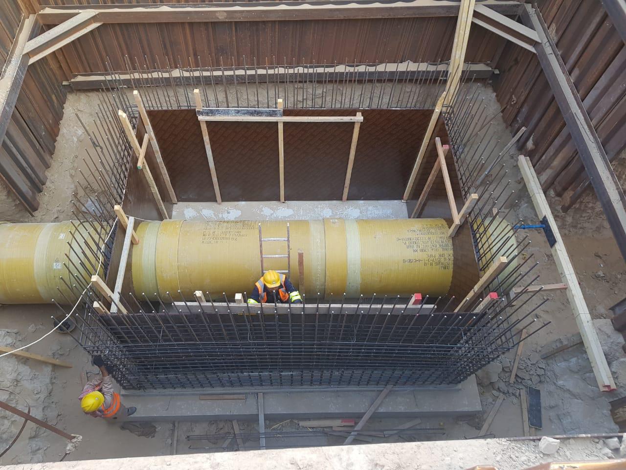 Pipeline system components laid out along a service road in an industrial outdoor setting